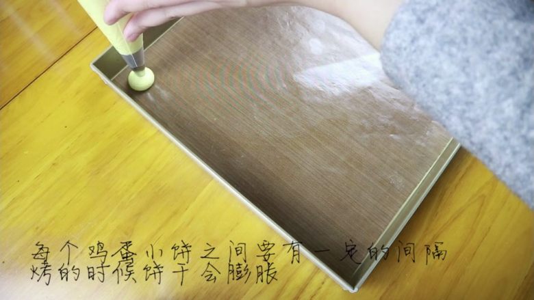 鸡蛋小饼干,然后在烤盘上挤小圆饼,每个饼干之间要有一定空隙,因为烤的时候还会膨胀