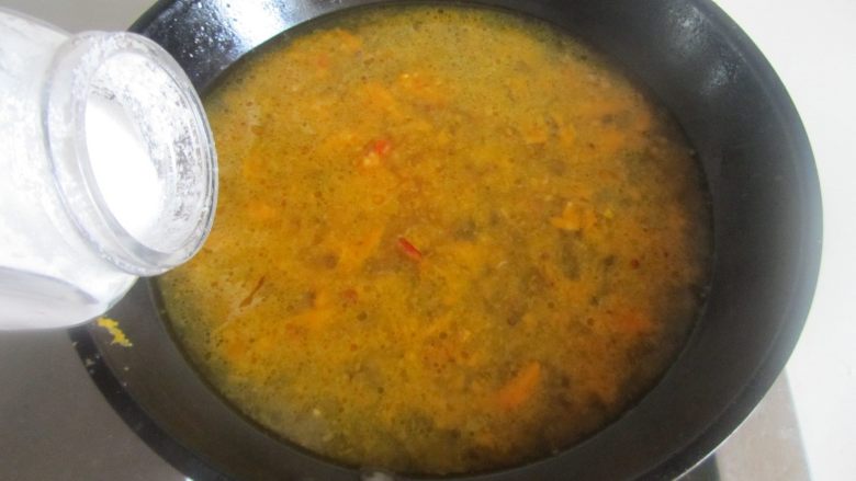 酸汤肥牛,用勺过滤下杂质, 再加入适量的盐和胡椒粉调味;