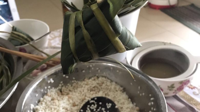 肉粽子,绕完三圈棕叶可能还剩一截,直接拉棕叶的根部那,拉紧就行,后续粽子就通过这个棕叶根部与别的粽子绑到一起
