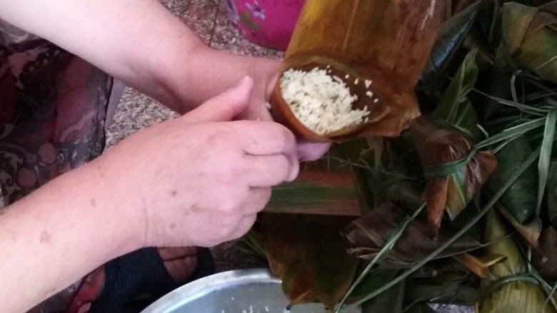 粽横天下―粽子,首先,拿两片粽叶卷成漏斗状,将泡好的糯米放在漏斗内就,再用筷子戳下,这样不会有缝隙,注意不要装太满,否则会溢出。