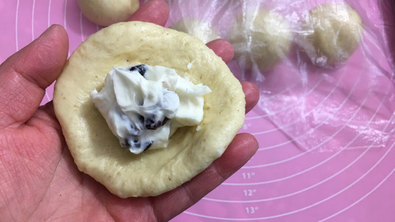 全麦蔓越莓奶酪包,15分钟后取一个面团擀圆,加入奶酪馅。
