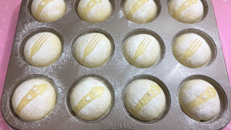 全麦蔓越莓奶酪包,用叉子或其它工具,放在面包顶部,在面包上表面均匀的筛上干粉。