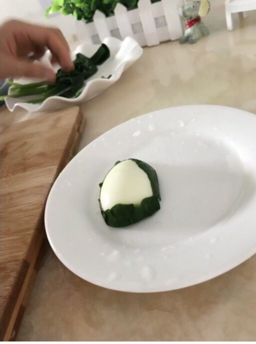 快乐的小青蛙,一片菠菜放在鸡蛋下面,把鸡蛋包起来。