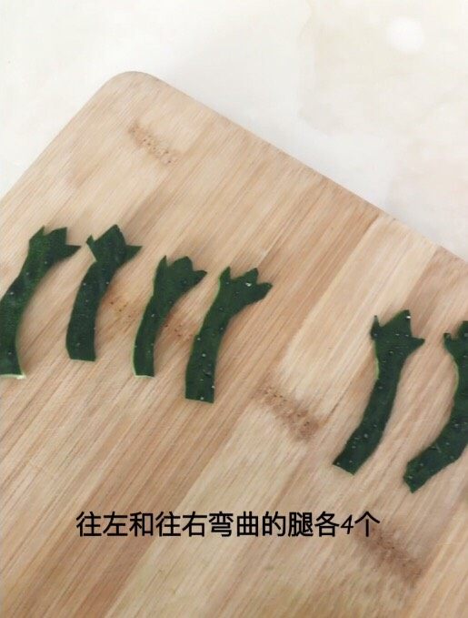 快乐的小青蛙,<a style='color:red;display:inline-block;' href='/shicai/ 54'>黄瓜</a>皮切成青蛙腿的样子,向左和向右弯曲的各4个。