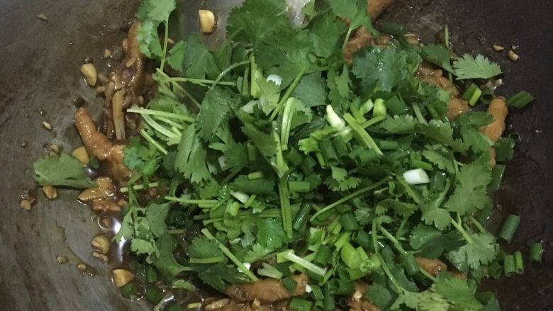 香辣鸡爪,关火再倒入少许蚝油 接着是香菜和葱末 拌下后就可以盛盘了