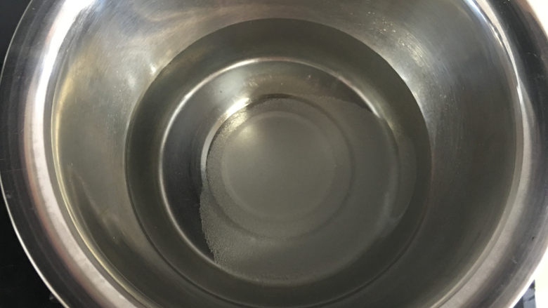 芒果水晶果冻,将纯净水和白糖放入盆中,放在燃气灶上小火加热。