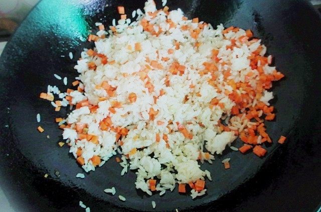 炒饭蛋糕,伪装成小蛋糕的鸡蛋炒米,用饭铲把米饭彻底炒散,颗粒分明时加入盐,胡椒粉调味,一点鸡精炒匀。