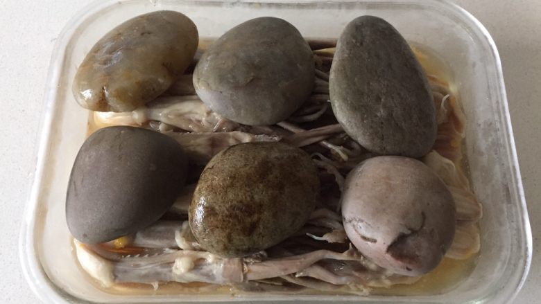 糟卤鸭舌,压上石块,糟卤的水没过鸭舌为准。
