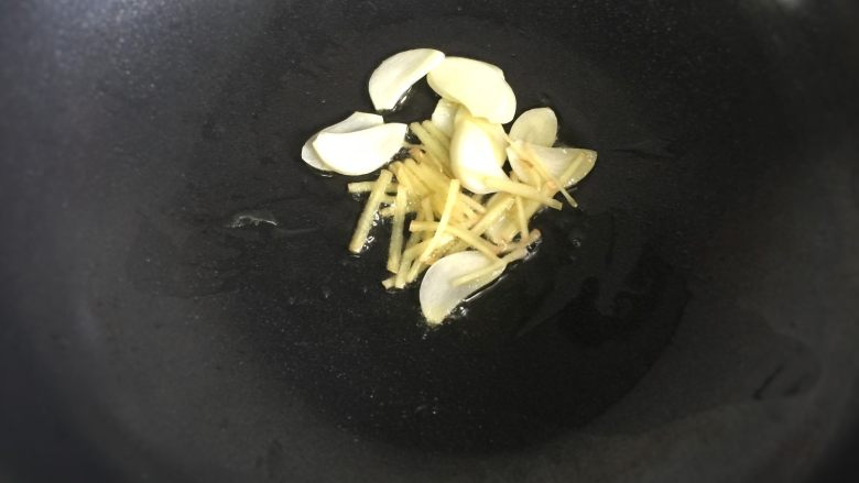 上汤娃娃菜 ,热锅加油,把蒜和姜煸炒出香味。