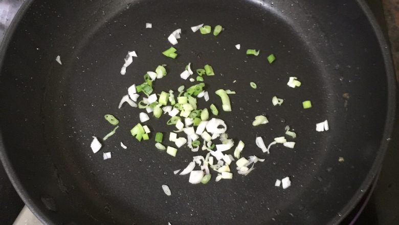 椒盐猪蹄,将锅里的油倒出,这时的锅底还是油油的,倒入切碎的小部分葱花,中火翻炒至葱花变黄