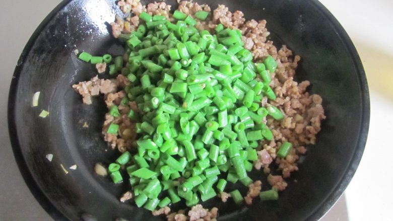 肉末橄榄菜炒豆角,微微煸炒干后加入焯煮好的豆角丁进去翻炒;