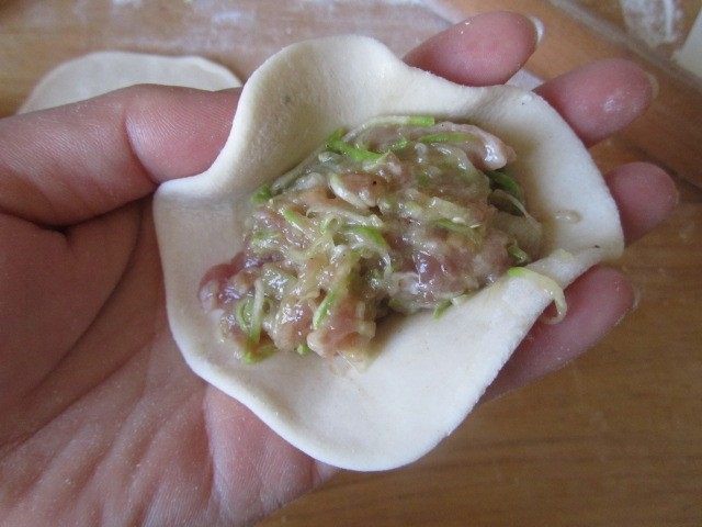 西葫芦肉馅锅贴,擀成圆片后中间包入西葫芦肉馅;