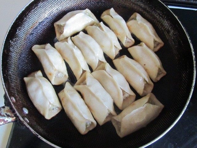 西葫芦肉馅锅贴,水快干时,转为小火, 慢慢的将锅贴煎至金黄色;