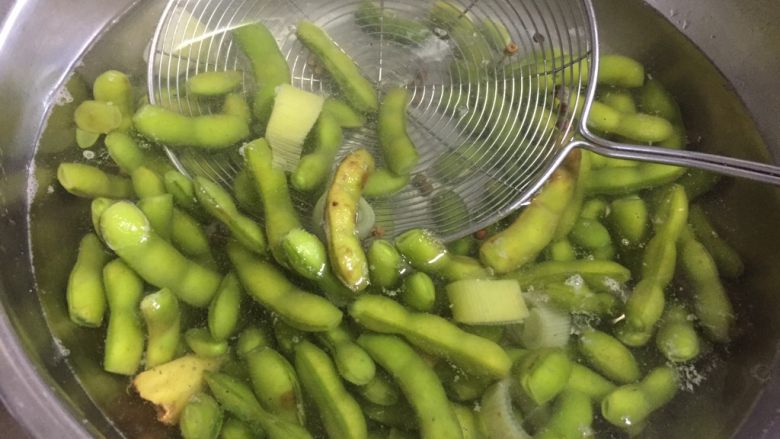 糟卤毛豆,煮熟的毛豆捞出,放在冷开水浸泡至冷却。