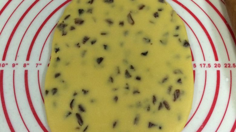 葡萄干奶酥,把面团放在案板上压扁,用擀面杖擀成厚约0.8厘米的面片。