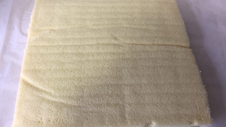 虎皮蛋糕卷,冷却到四十度左右,将蛋糕倒扣在虎皮上,轻轻撕去油纸。