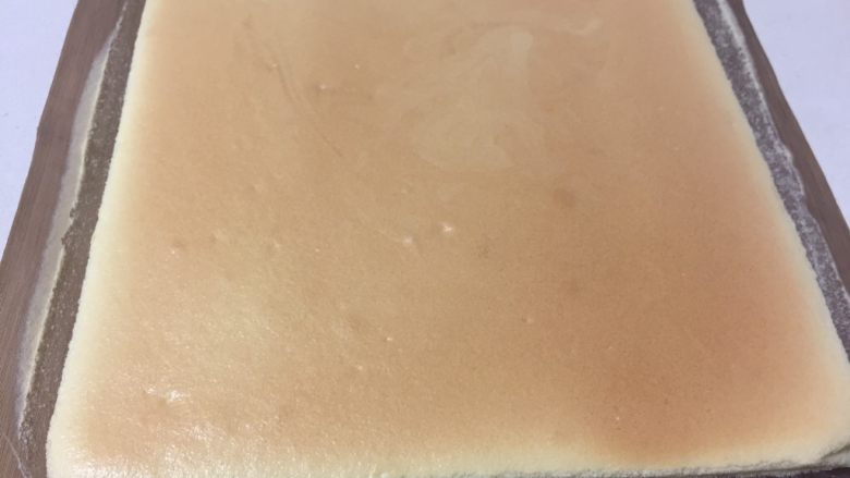 虎皮蛋糕卷,烘烤结束取出烤盘轻摔一下,把蛋糕卷连同油纸移至晾网架上冷却。