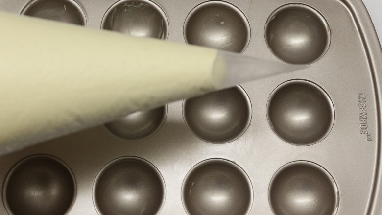 巧克力棒棒糖蛋糕,做好的面糊装在裱花袋里面,底下剪个口,再挤到棒棒糖模具里面