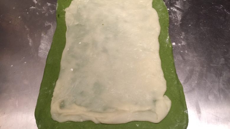抺茶麻薯软欧,案板洒少许干粉,将主面团擀成长方形,麻薯分成3份,也分别长方形,分别叠放在主面团上