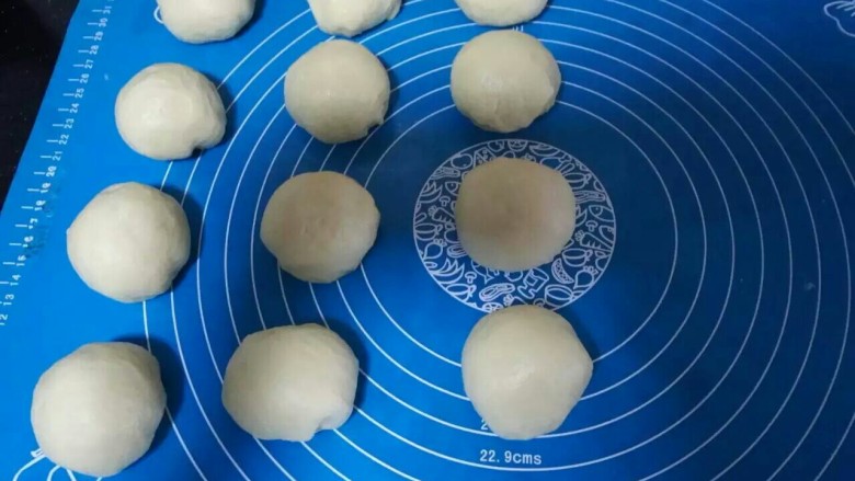 日本牛奶卷,分成12个相同的圆剂子,用保鲜膜松弛15分钟,用手按扁排气。