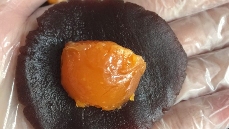 没错,高筋粉也能做蛋黄酥,然后把红豆沙按压成饼,包入半个蛋黄,收紧口,包成圆形