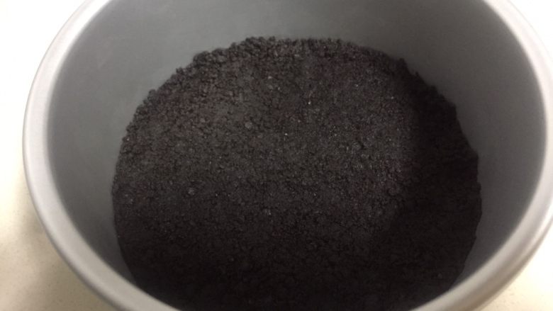 百香果芒果流心慕斯,准备一个六寸的戚风模具,裁一张和模具底部一样大小的油纸放在模具底托上。把饼干碎铺在模具底部,用工具压实压紧入冰箱冷藏半小时。
