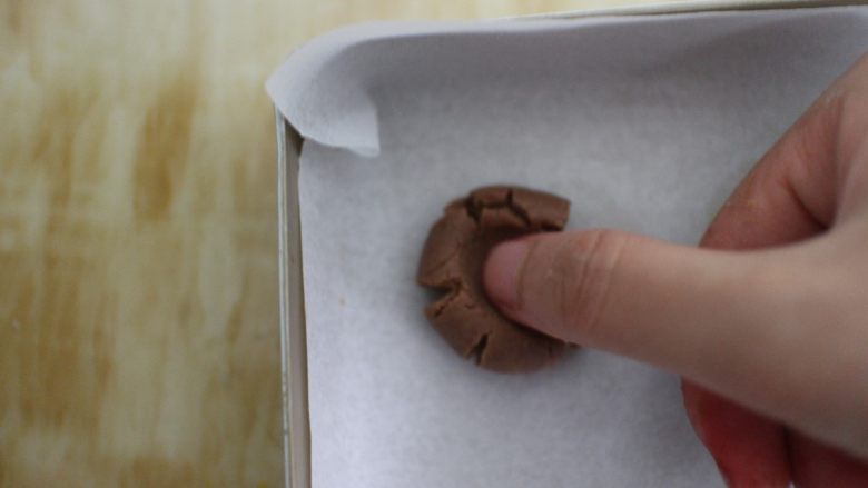 巧克力豆玛格丽特饼干,放在烤盘上,用大拇指去按压它,使它形成一个自然的裂痕即可