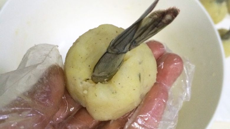 黄金虾球,把虾尾插入土豆虾球中,收好边,捏紧了,10个虾球全部操作完成。