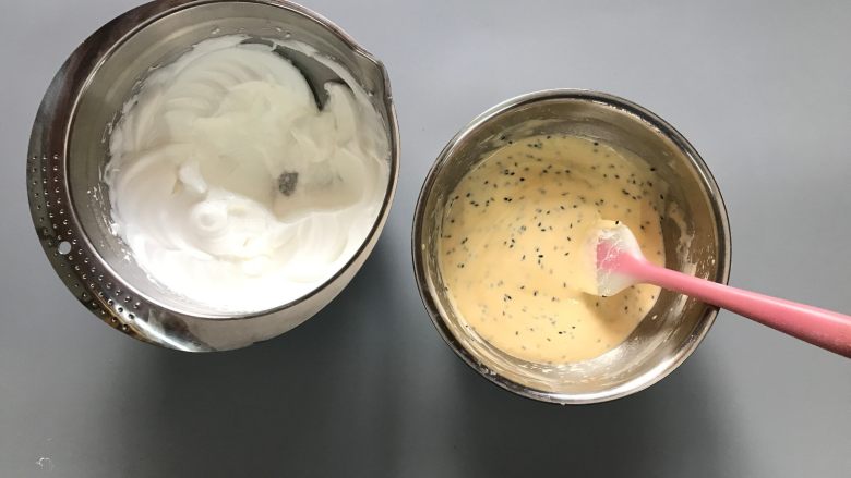 酸奶芝麻戚风,先将1/3蛋白霜放入蛋黄糊。切拌加翻拌,混合均匀。