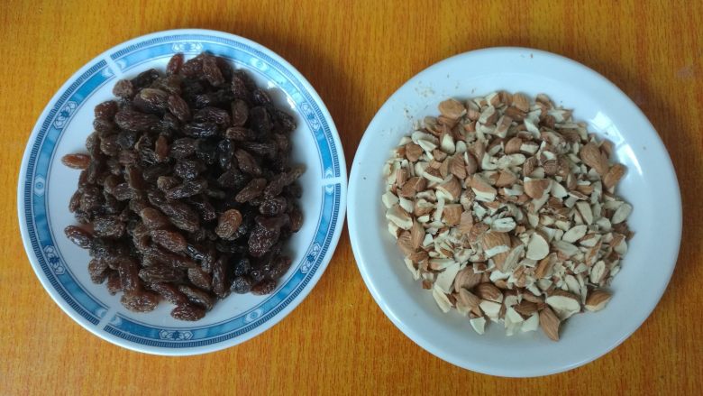 无油健康版 黑糖干果软欧,葡萄干用水浸泡3分钟,捞出,用厨房纸巾擦干,杏仁切成粒。