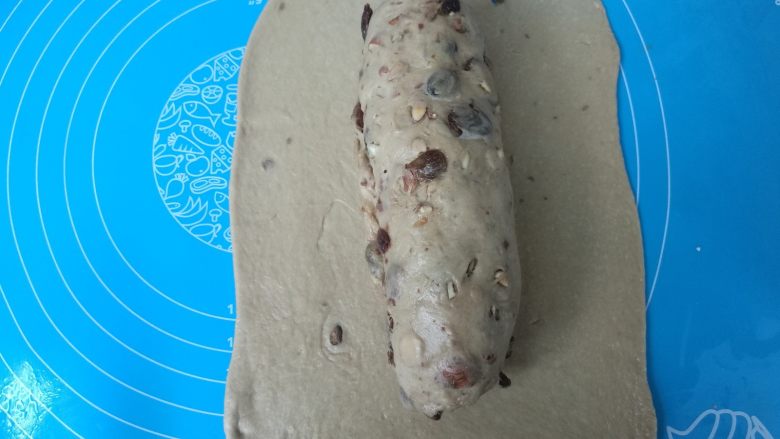 无油健康版 黑糖干果软欧,没有果料的面团擀成方形片,步骤8的果料面团放进中间。