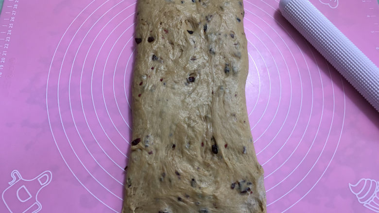 红糖蔓越莓吐司,取出发酵好的面团进行排气,擀成长方形后翻面,底部按薄。