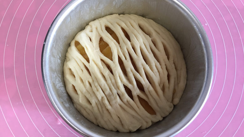面包机版黄桃面包派,然后小心的将拉网放入模具中,覆盖在黄桃上,四周用手压一下,和底下面饼粘合在一起。