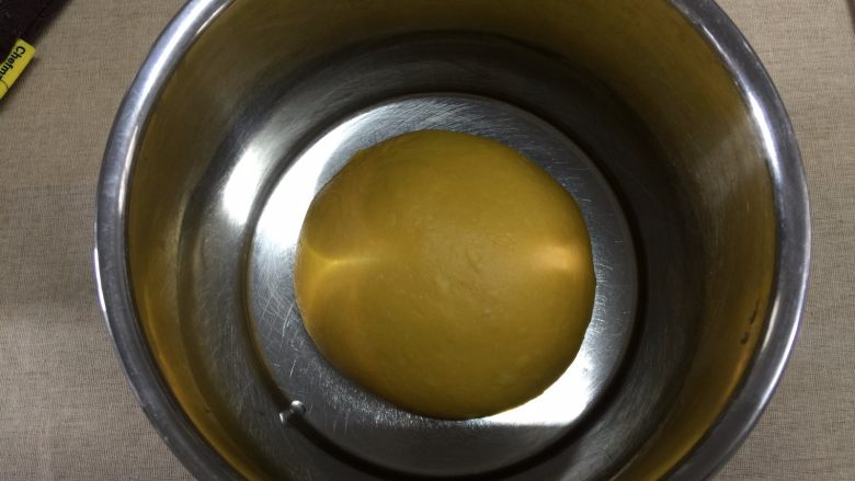 南瓜汉堡包,程序结束后,取出面团,揉圆后放置干净的容器内发酵