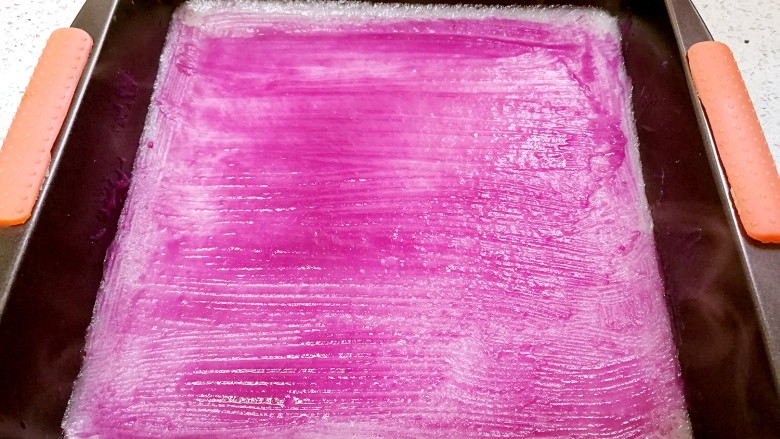紫薯糯米卷,蒸好的糯米皮立即取出,趁热刷上紫薯糊,静置晾凉。