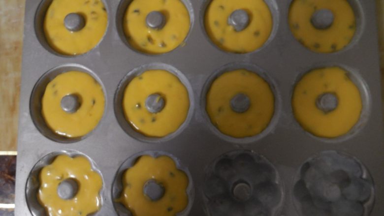 百香果小蛋糕,将面糊挤入到模具中，模具事先做好防沾处理（模具内涂一层软化的黄油，然后在撒上面粉，接着倒掉多余的面粉，这样一个简单的防沾处理就做好了）