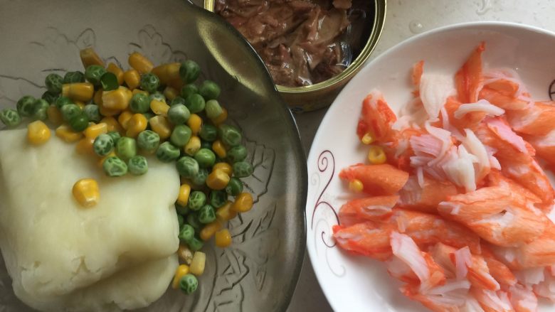 蟹柳土豆泥竹炭面包卷,面团发酵期间准备馅料:土豆放入微波炉加热后放入保鲜袋中用擀面杖擀成土豆泥、杂蔬焯水、蟹柳和金枪鱼