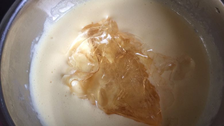 巧克力三重奏慕斯,提前用冷开水把吉利丁片泡软后,放入牛奶蛋黄糊里,搅拌至融化,然后把液体过筛一下,冷却