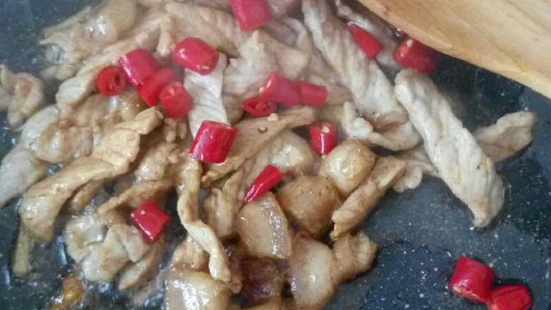 小陀螺的农家味小炒茭白,然后就是放入酱油和香料粉，使肉更香，当肉质有点变黄，放入切好的辣椒。翻炒一阵。