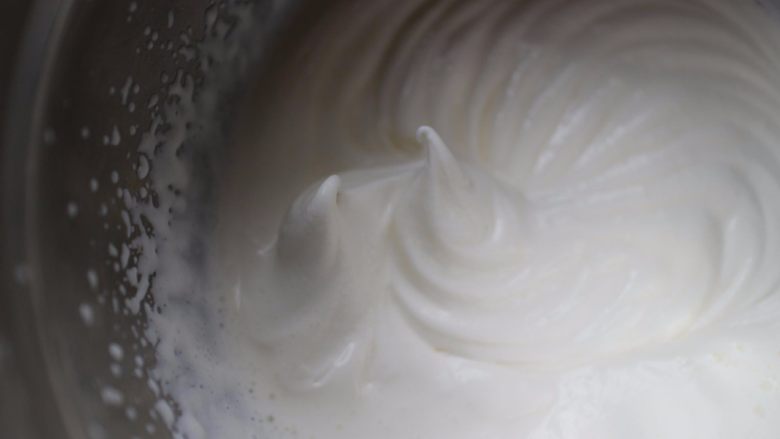 黑巧慕斯盒子蛋糕,搅打至提起打蛋头,奶油在打蛋头上呈现弯钩状即可。也就是7分发的样子,奶油打好的状态图,有纹路,但是很浅,奶油很软的状态!切记不能打发的过硬
