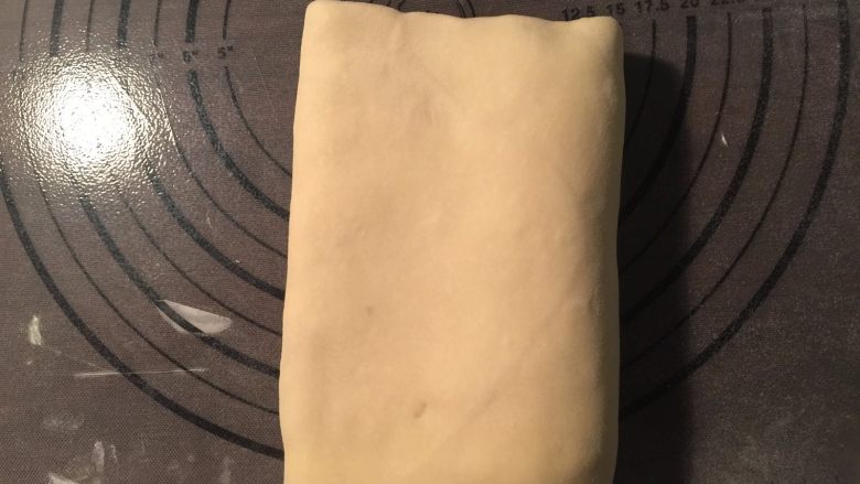 流沙起酥包,从面片的一端1/3处把面片向中间翻折,另一端也从1/3处向中间翻折。这是第一次三折;再用擀面杖擀开,重复上面再一次三折。这是第二次三折,把三折好的面片再次放入冰箱冷藏松弛20分钟,重新擀成长方形,再做一次四折