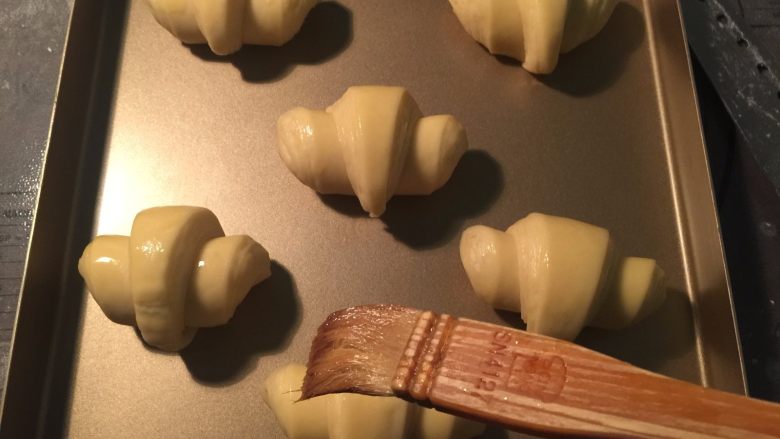 流沙起酥包,发酵完成后取出,在表面刷一层全蛋液