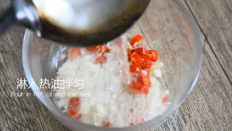 夏天最爽口的搭配——皮蛋拌黄瓜,取一空碗倒入蒜末,小米椒圈,淋上热油拌匀