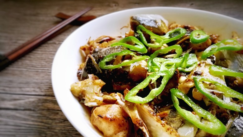 蒜香豆豉蒸鱼头,把青椒圈摆放在鱼头上,再浇上热油。