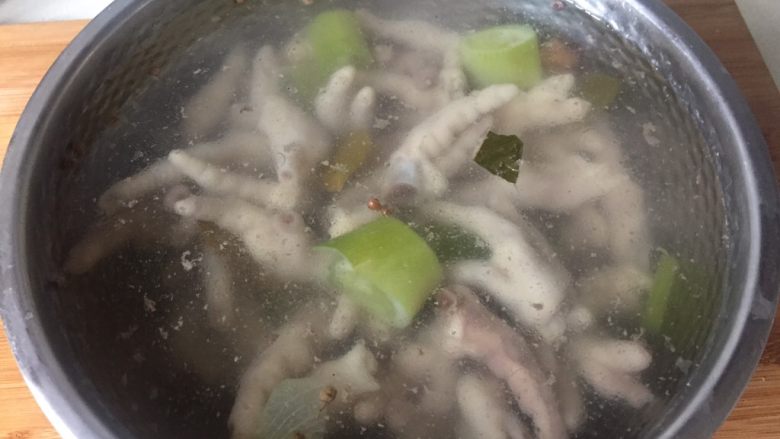 酸辣鸡脚,把煮熟的鸡爪捞出,放进事先准备好的冷开水里浸泡至完全冷却。