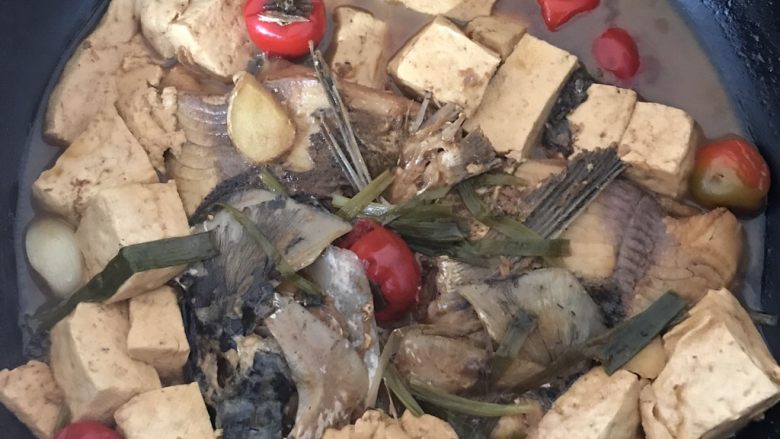 鱼头炖老豆腐,锅烧热,倒入油。放入剥好的蒜4颗,泡椒,生姜,再放入鱼头煸一下,两面都煸。然后放入料酒,少许醋,生抽老抽,开水~