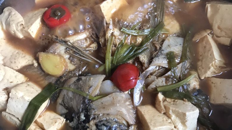 鱼头炖老豆腐,炖15分钟放入白糖和豆腐!葱条。继续15分钟小火偏中火炖。炖到豆腐上色入味,就可以起锅了。