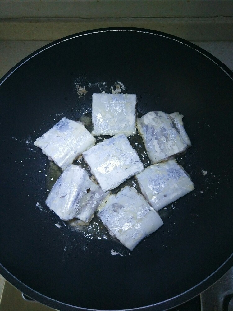 糖醋带鱼,将腌制好的带鱼裹蛋清液及面粉，摆放锅中，中火煎制。