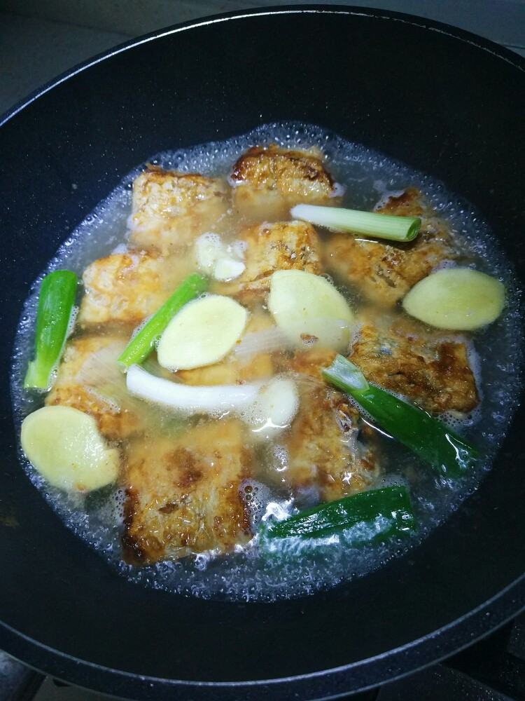 糖醋带鱼,加入切好的葱段，姜片和蒜。