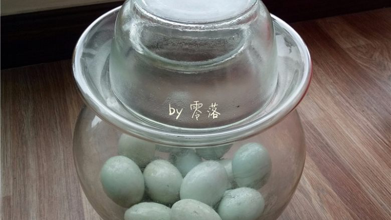 自制咸鸭蛋,将鸭蛋放进无油无水的容器里,倒入浸泡过鸭蛋的高度白酒,放置一晚;我用了泡菜坛;高度白酒有助于出油,而且有提香的作用;